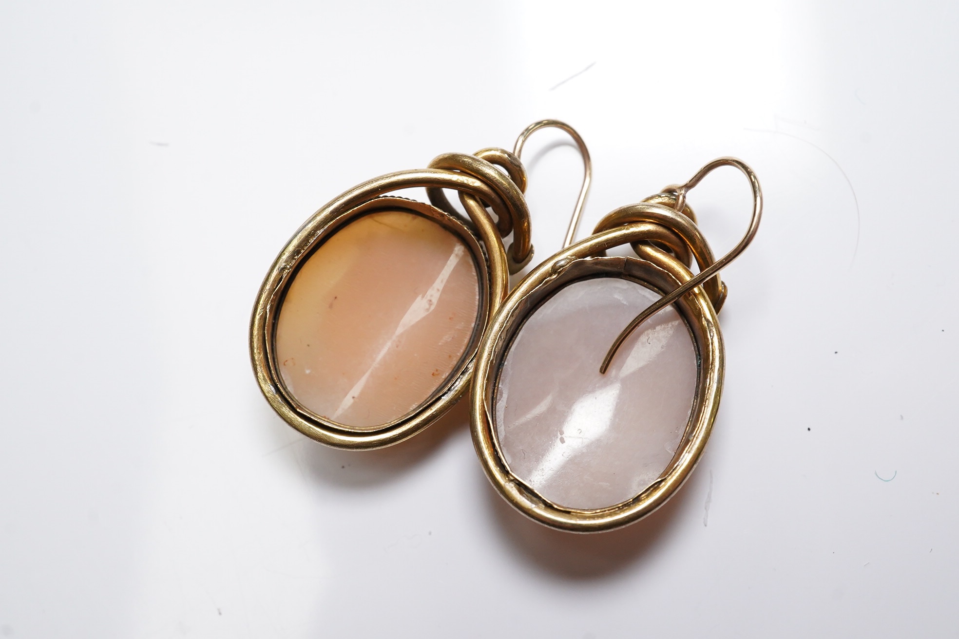 A pair of yellow metal mounted oval cameo shell drop earrings, carved with head of a lady to dexter or sinister, shell approx. 20mm. Condition - fair